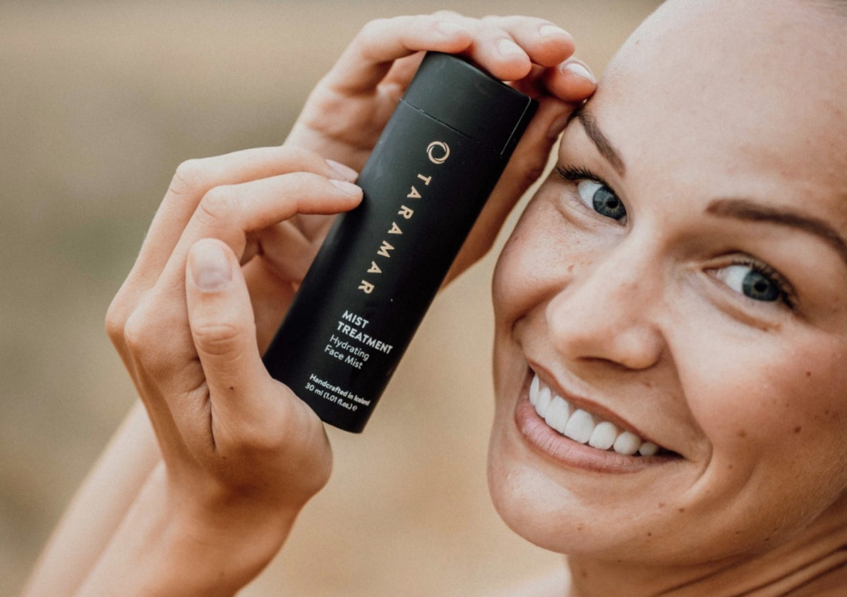 Naine hoiab Mist Treatmenti pudelit näo juures