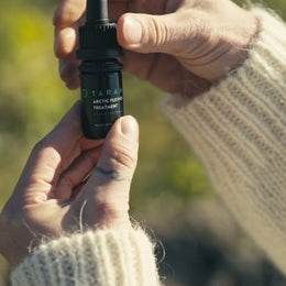 Käed hoiavad TARAMARi Arctic Flower Treatment pudelit
